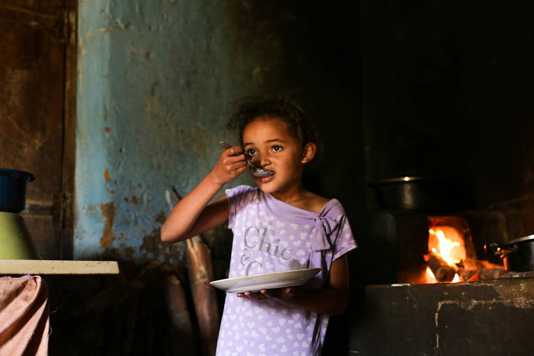 No povoado de Lagoa Preta, Marizete, 7, come prato servido pela mãe, Dalva Novaes Viana, 47. Em 2017, 15 pessoas morreram por dia de desnutrição, e 37% das mortes ocorreram no Nordeste
