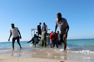 Migrants are seen after being rescued by Libyan coast guard in Tripoli