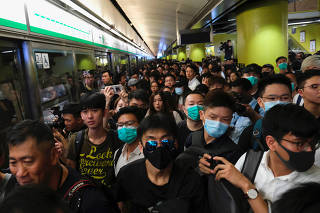 Anti-extradition bill demonstrators block a Mass Transit Railway (MTR) train in Hong Kong