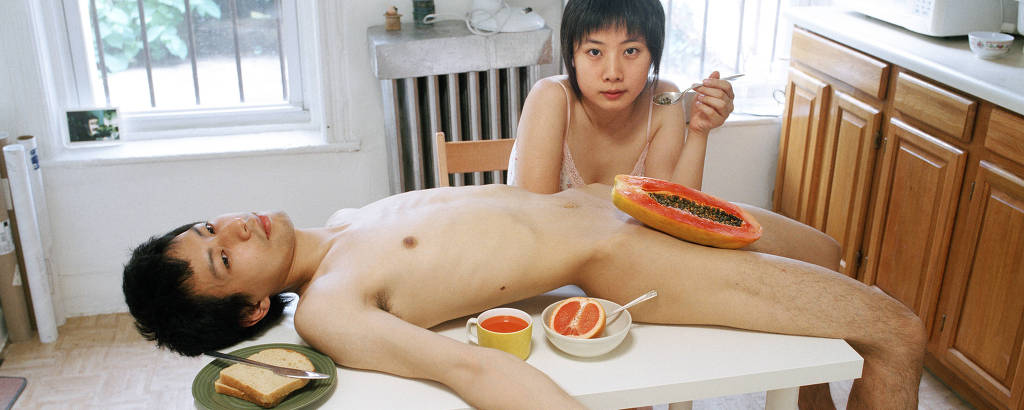 Homem e mulher comendo mamão