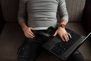 A man watches an adult video on a laptop while sitting on the couch. The concept of porn, men's needs, pervert, lust, desire, loneliness.