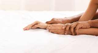Black man and woman hands having sex on bed