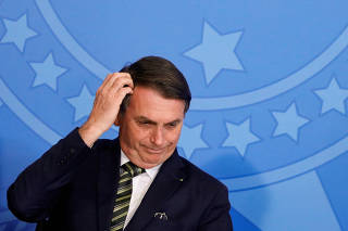 FILE PHOTO: Brazil's President Jair Bolsonaro gestures during a review and modernization ceremony of occupational health and safety work at the Planalto Palace in Brasilia