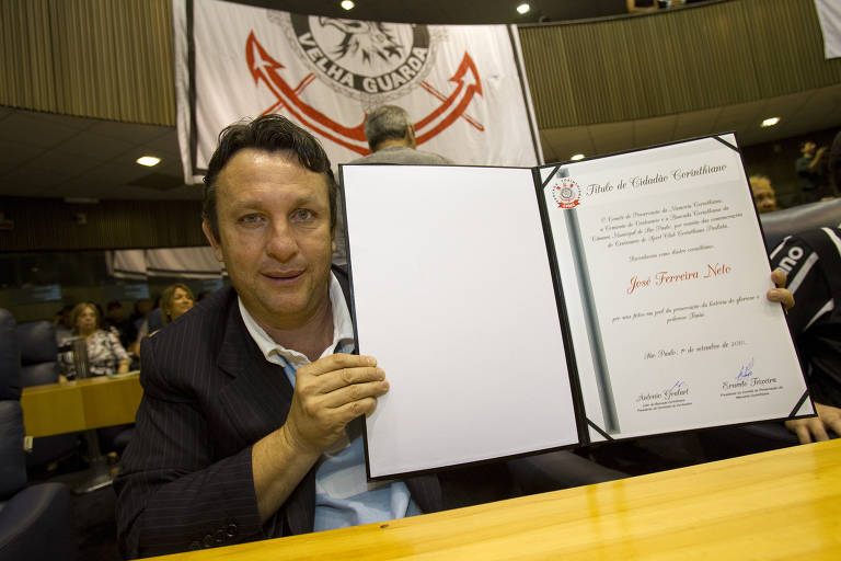 Neto exibe "título de cidadão corinthiano", em ato na Câmara Municipal de São Paulo referente ao centenário do Corinthians