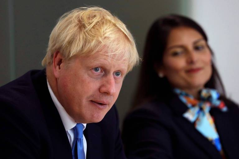 O primeiro-ministro do Reino Unido, Boris Johnson, participa de reunião do Conselho de Policiamento Nacional acompanhado da secretária do Interior, Priti Patel, em Londres, na quarta (31)