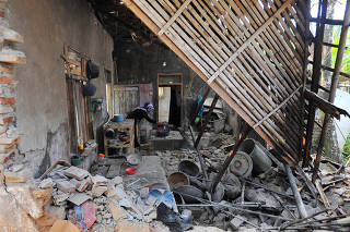 Woman is seen inside her house damaged after an earthquake hit in Pandeglang