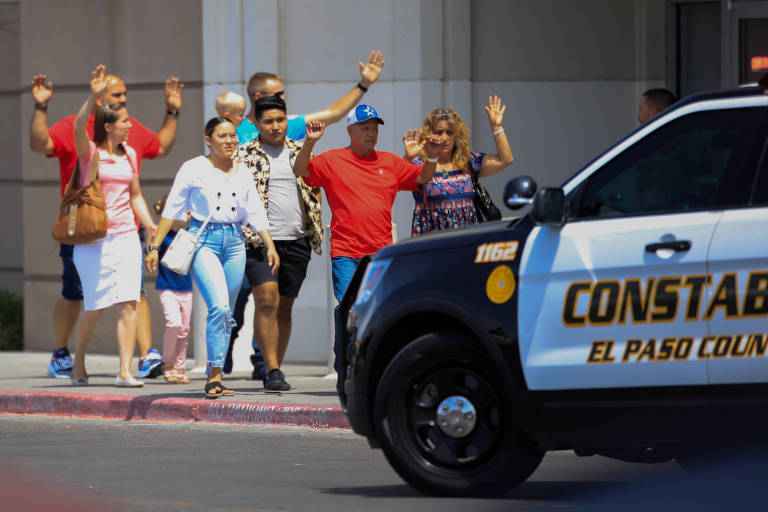 Com as mãos levantadas, pessoas deixam o prédio do Walmart em El Paso, Texas