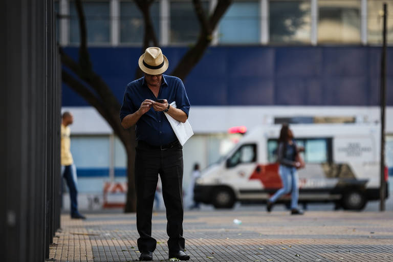 Paulistanos usam celular na região central de SP; cerca de um terço dos registros eletrônicos de roubos e furtos desses aparelhos é rejeitado