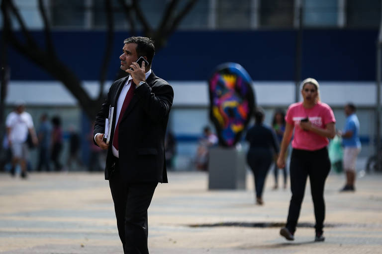 Paulistanos usam celular na região central de SP; cerca de um terço dos registros eletrônicos de roubos e furtos desses aparelhos é rejeitado