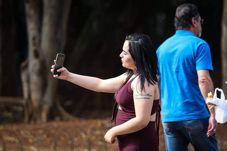 Paulistanos usam celular na região central de SP; cerca de um terço dos registros eletrônicos de roubos e furtos desses aparelhos é rejeitado