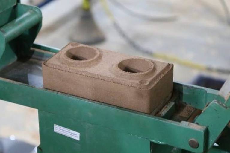 prensa manual verde usada para fazer tijolos sustentáveis