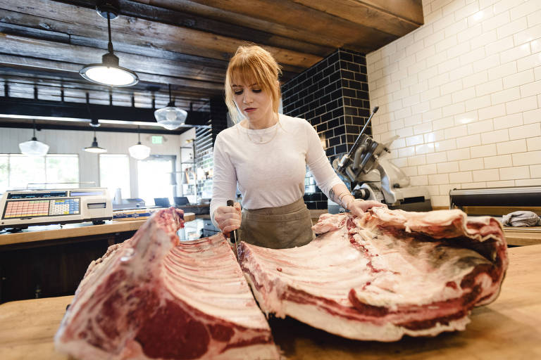 Kate Kavanaugh quebra costela de carne bovina em sua loja, a Western Daughters Butcher Shoppe, em Denver