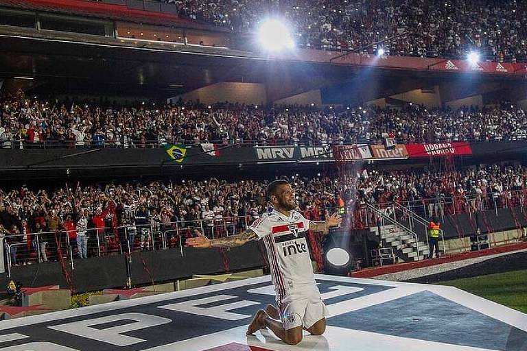 Daniel Alves se ajoelha no escudo do São Paulo no estádio do Morumbi durante sua apresentação oficial para mais de 44 mil torcedores