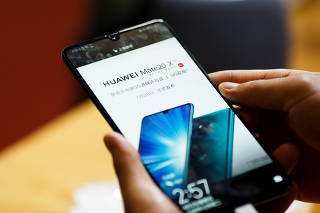 A man holds a Huawei Mate 20 X 5G smartphone at the International Consumer Electronics Expo in Beijing