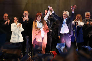 Presidential candidate Alberto Fernandez and his running mate former President Cristina Fernandez de Kirchner, wave on stage during their closing campaign rally ahead of primary elections, in Rosario, Argentina