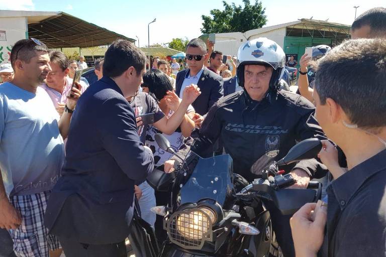 Bolsonaro cercado de apoiadores enquanto passeia de moto em Brasília