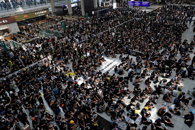 Manifestantes fazem ato no aeroporto internacional de Hong Kong, nesta segunda-feira (12)
