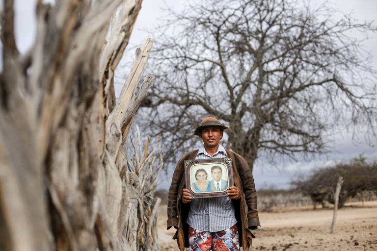 Avelar segura o retrato de seus sogros próximo a sua casa, em Ladeira Grande
