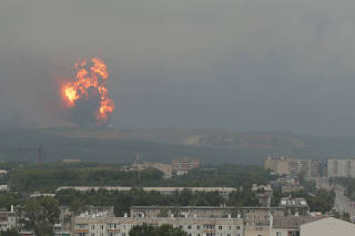 A view shows flame and smoke rising from the site of blasts at an ammunition depot in Krasnoyarsk region
