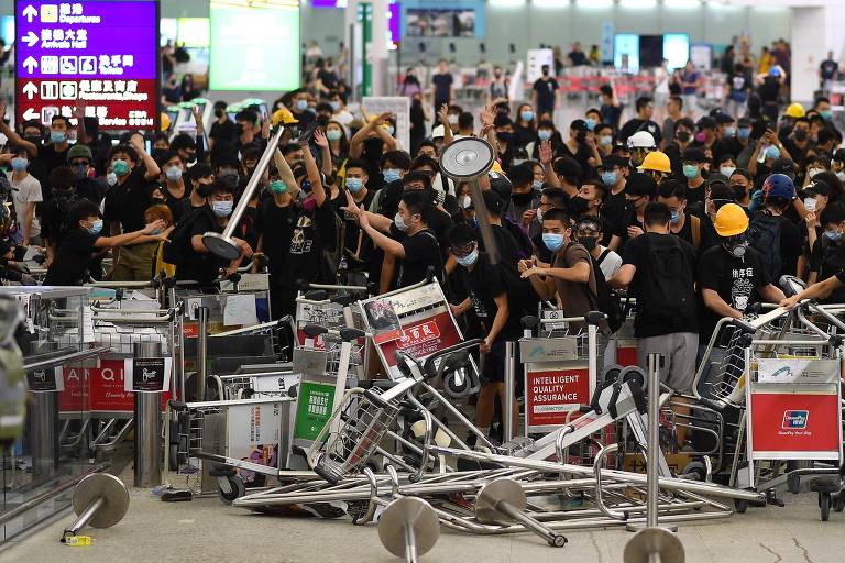 Após três dias de protestos pacíficos no aeroporto internacional de Hong Kong, manifestantes e polícia entram em confronto no local