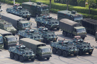 Military vehicles are parked on the grounds of the Shenzhen Bay Sports Center in Shenzhen