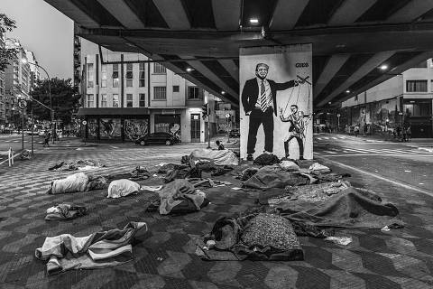 Sv£o Paulo, BRASIL. 23/06/2019. Pertences de moradores de rua ocupam uma calvßada embaixo do Minhocv£o em Sv£o Paulo. Ao fundo um grafite ironizando a relavßv£o entre o presidente Jair Bolsonaro e o presidente norte-americano Donald Trump. ( Foto: Lalo de Almeida/ Folhapress ) MUNDO  *** EXCLUSIVO FOLHA*** ORG XMIT: AGEN1907250755921133