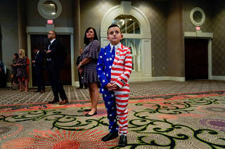 9-year-old Reed Elliotte listens to U.S. President Donald Trump speak at the AMVETS American Veterans convention in Louisville