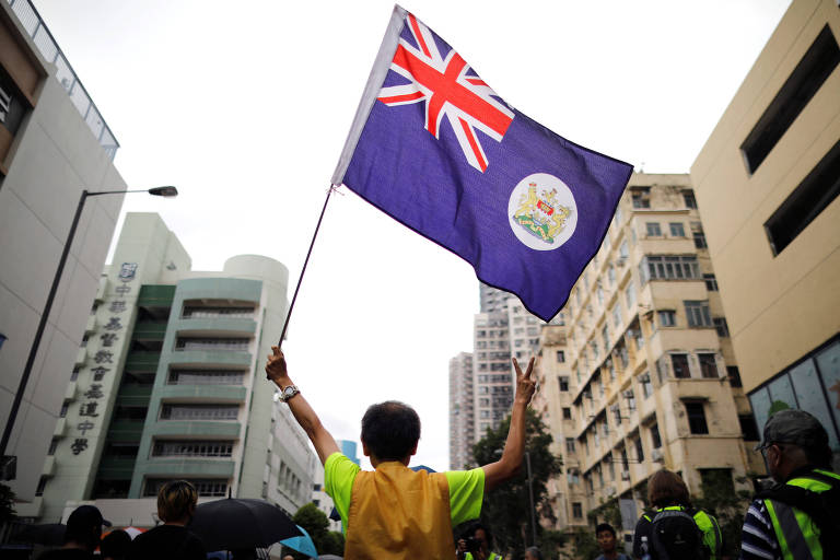 Manifestante segura bandeira do período colonial durante protesto em Hong Kong 
