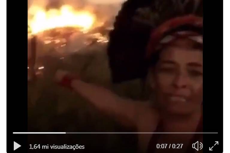 Vídeo mostra no primeiro plano mulher indígena com cocar chorando e apontando ao fundo incêndio na mata. Ela está com feição de desespero
