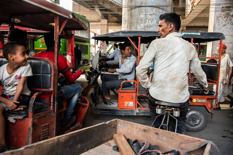 Motoristas de riquixás elétricos esperam que o tráfego diminua do lado de fora da estação de metrô de Nova Déli, na Índia,