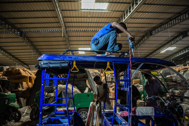 Trabalhador da maior fabricante de riquexás elétricos de Saarthi monta veículo em um armazém em Nova Déli