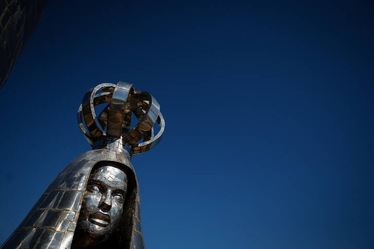 Cabeça de estátua com manto e coroa metálicos