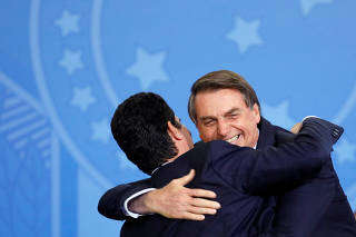 Brazil's Justice Minister Moro hugs Brazil's President Bolsonaro during a launching ceremony at the Planalto Palace in Brasilia