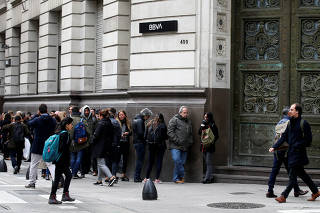 People line up outside BBVA bank before its opening, in Buenos Aires
