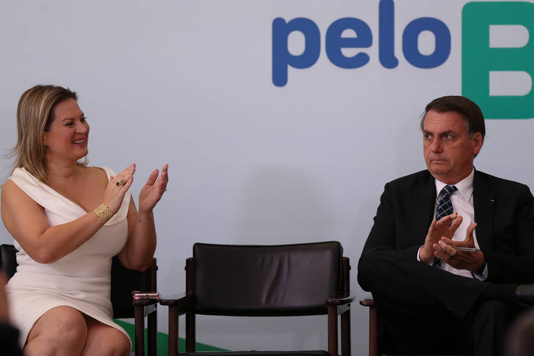 A deputada Joice Hasselmann (PSL-SP) bate palma durante cerimônia no Palácio do Planalto ao lado de Jair Bolsonaro
