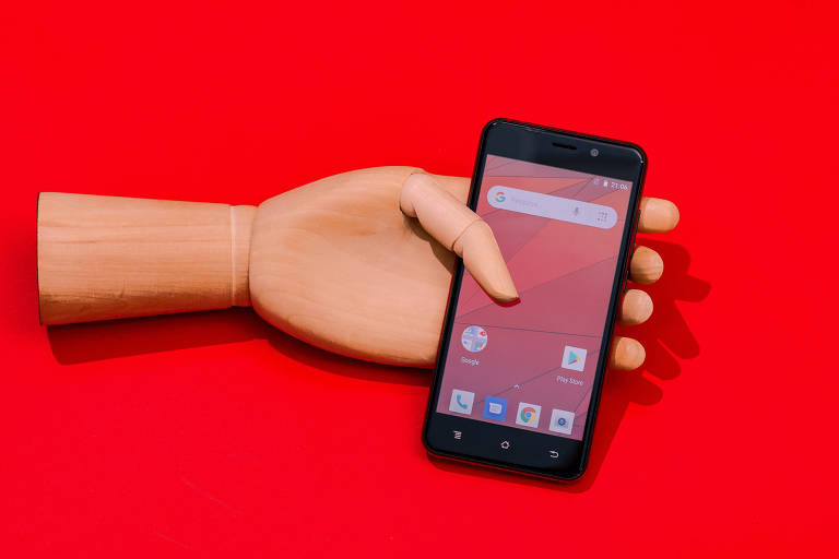 mão segura smartphone em fundo vermelho