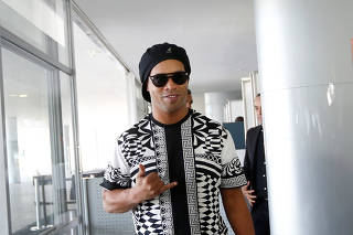 Former soccer player Ronaldo Assis de Moreira (popularly known as Ronaldinho Gaucho) arrives to a meeting with Brazil's President Jair Bolsonaro (not pictured) at the Planato Palace in Brasilia