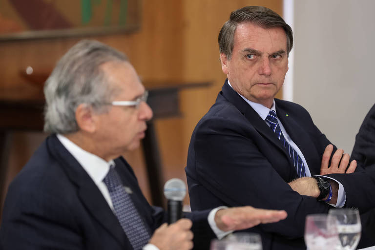 O presidente Jair Bolsonaro  ao lado do ministro da Economia, Paulo Guedes; Bolsonaro propôs revisão no teto, mas ministério se opõe 