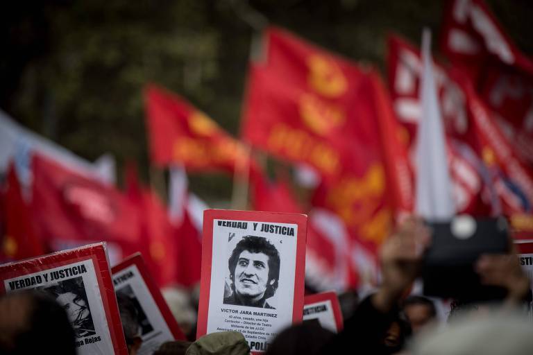 Ativistas da organização chilena de defesa dos direitos humanos "Pessoas presas e desaparecidas" carregam retratos de vítimas da ditadura militar chilena (1973-1990) durante ato neste domingo (8)