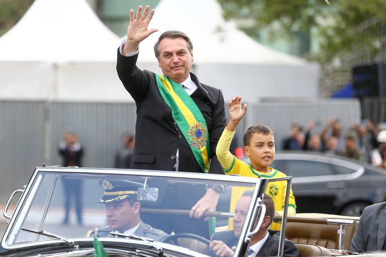 O presidente Jair Bolsonaro e o garoto Ivo Cesar Gonzalez, que estava entre o público na esplanada e foi chamado para subir no carro