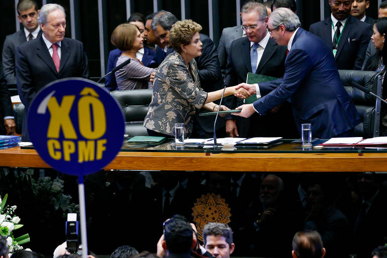 Em fevereiro de 2016, durante o segundo governo Dilma, o então ministro da Fazenda, Joaquim Levy, propôs a volta da CPMF para recompor às já prejudicadas contas públicas, o que foi rechaçado pelo Congresso. A oposição protestou com cartazes contra o imposto. Na foto, a ex-presidente cumprimenta o então presidente da Câmara dos Deputados Eduardo Cunha (PMDB-RJ)