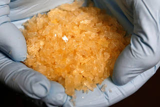 FILE PHOTO: A member of the German Criminal Investigation Division (BKA) displays Crystal Methamphetamine (Crystal Meth) during a news conference at the BKA office in Wiesbaden
