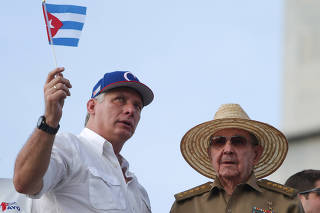 FILE PHOTO: Cuba's First Secretary of the Communist Party and former President Raul Castro speaks to Cuba's President Miguel Diaz-Canel as they watch the May Day rally in Havana