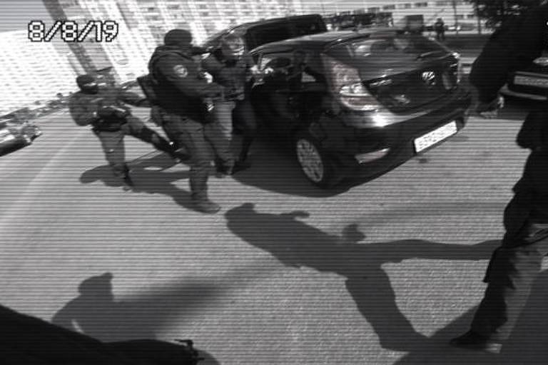 Amigo de Sergio é retirado do carro por atores vestidos como policiais