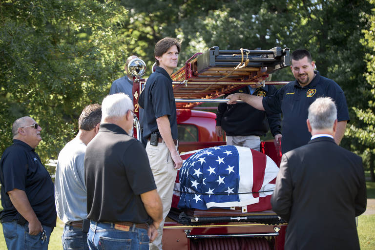 O caixão de Joe Heller é carregado em caminhão do Departamento de Bombeiros de 1941 que ele ajudou a restaurar