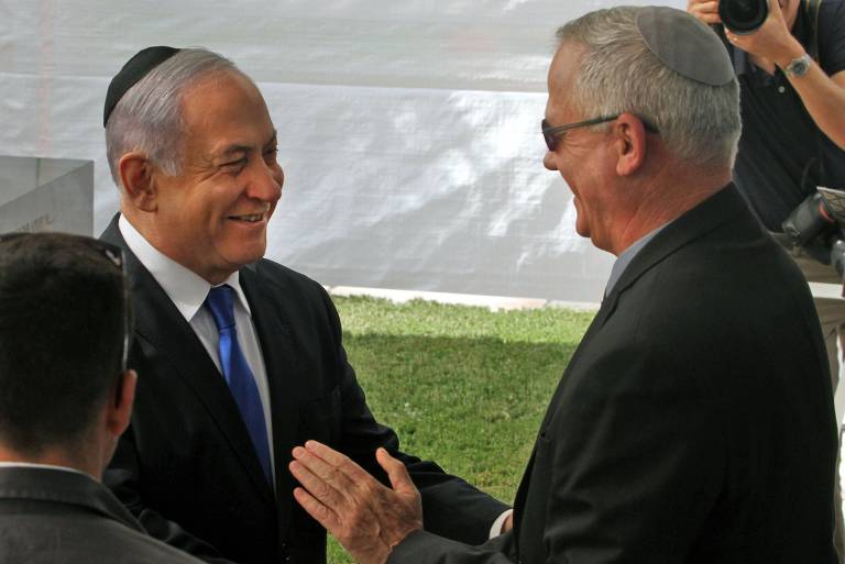O premiê de Israel, Binyamin Netanyahu, à esq., cumprimental Benny Gantz em em cerimônia em homenagem a Shimon Peres em Jerusalém