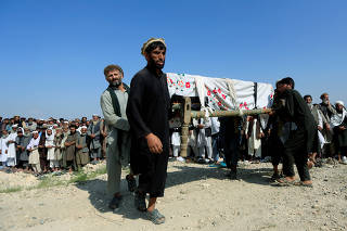 Men carry a coffin of one of the victims after a drone strike, in Khogyani district of Nangarhar province, Afghanistan