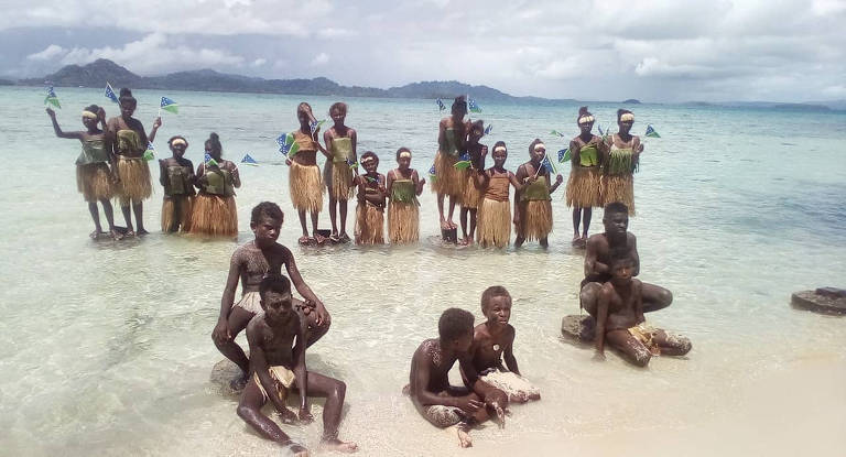 Em praia das Ilhas Salomão, estudantes posam para fotos em ato contra aquecimento global