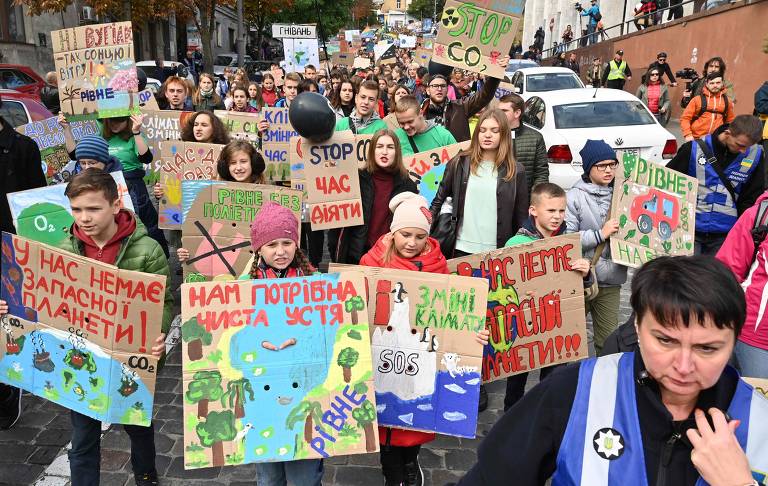 Em Kiev, na Ucrânia, crianças seguram placas e gritam slogans como "Greve na Escola pelo Clima", como parte de um protesto geral contra mudanças climáticas
