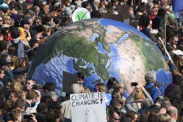 Em Munique, na Alemenha, grupo carrega um grande balão que representa o planeta Terra